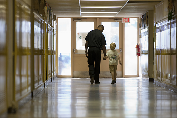 Teacher with student walking in school hall