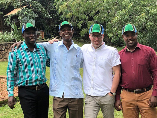 Benjamin, Aris, Matt, and Mitti wearing hats depicting Tanzania's flag.