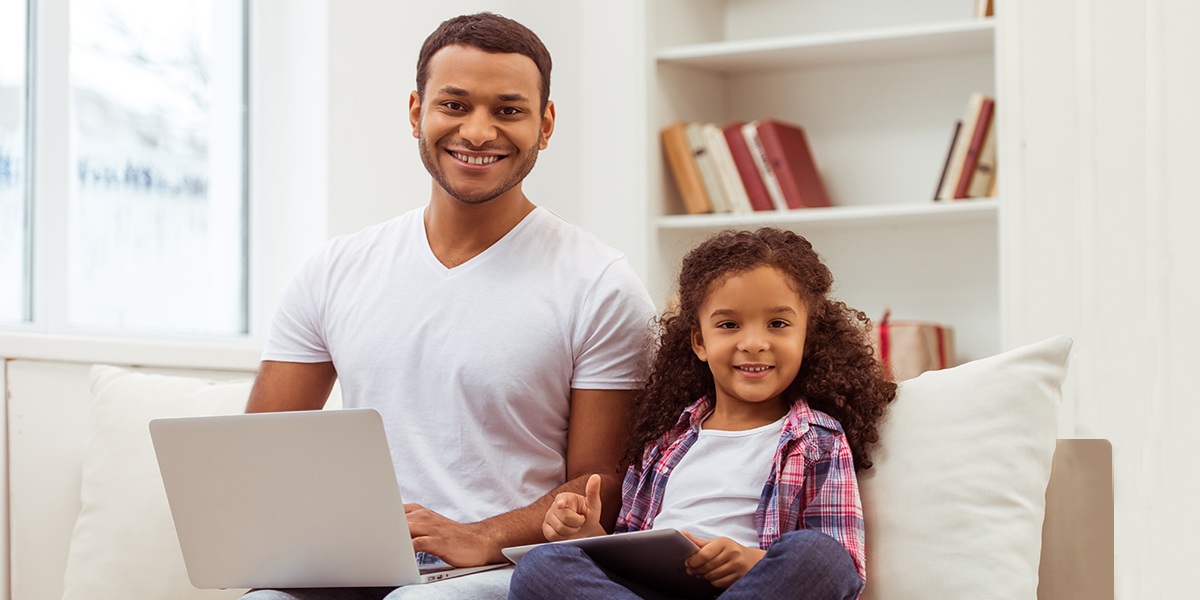 Father with daughter doing remote learning