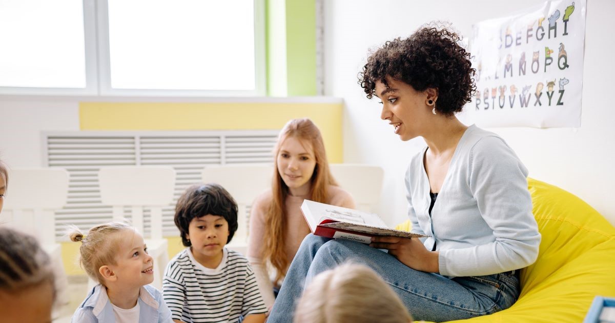 a person reading a book to children