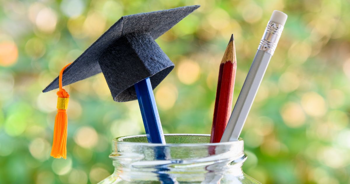 Black graduation cap or hat on pencil in bottle, depicts the power of success in education. 