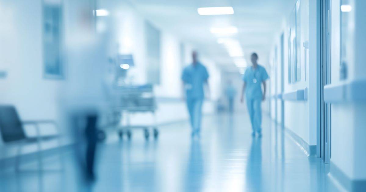 Two health care providers walking down a hospital hallway