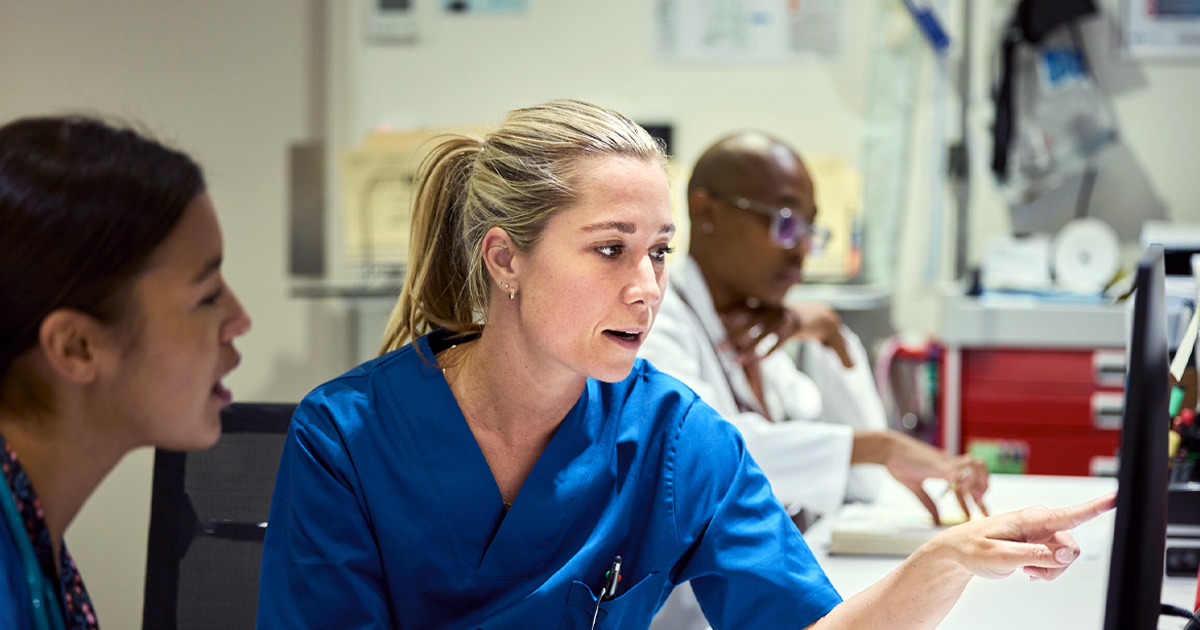 Nurses using computer at desk in hospital stock photo