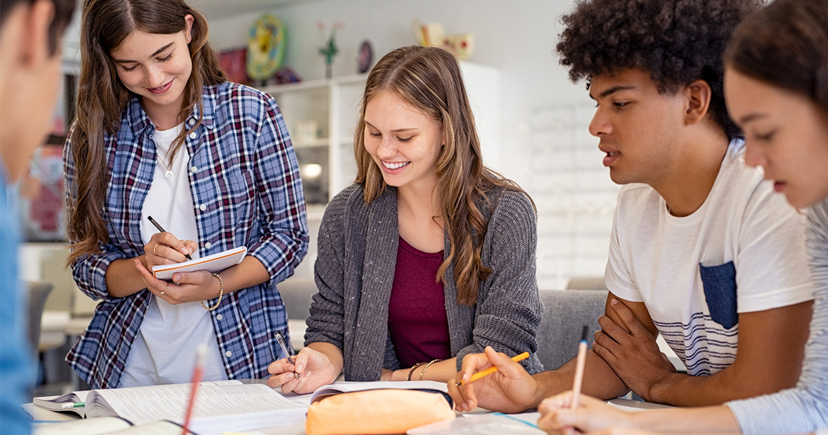  Group of students sitting at a table working on an assignment.