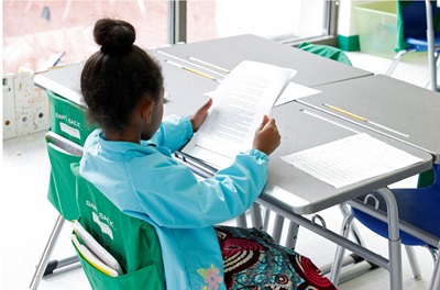 Girl sitting at school desk reading