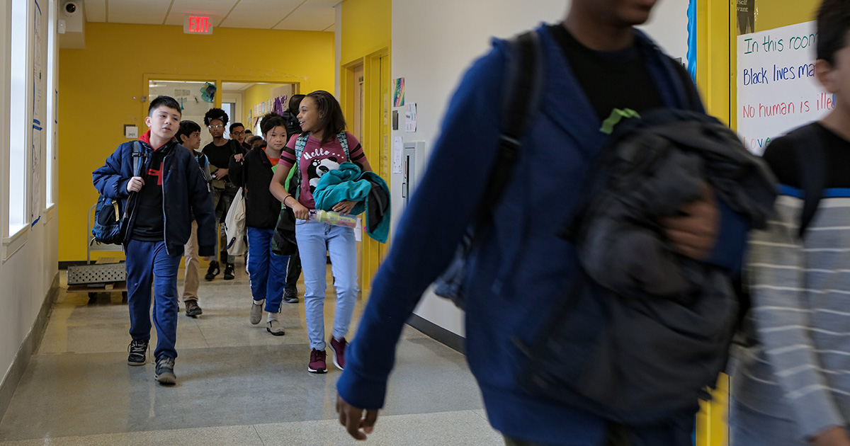 Students in school walking down a hall