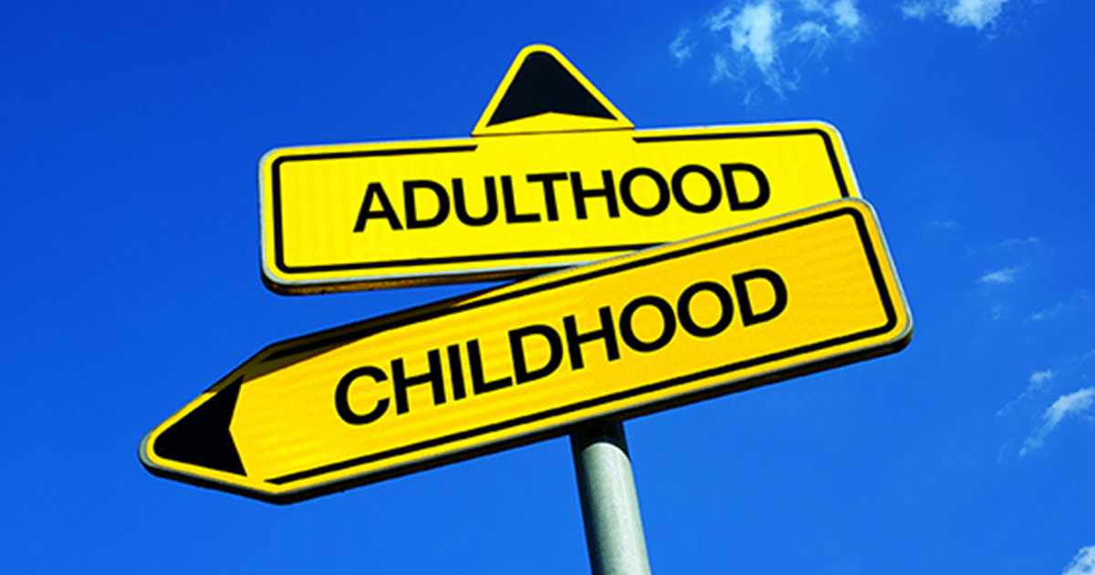 Bright yellow road signs pointing in different directions labeled Adulthood and Childhood, against a bright blue sky background. 