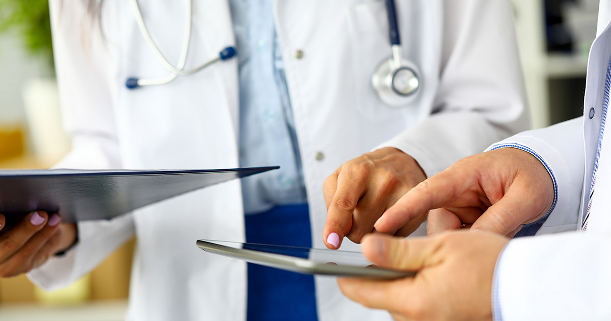 Doctors looking at a tablet