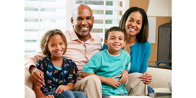 Smiling family sitting on a couch together building strong families