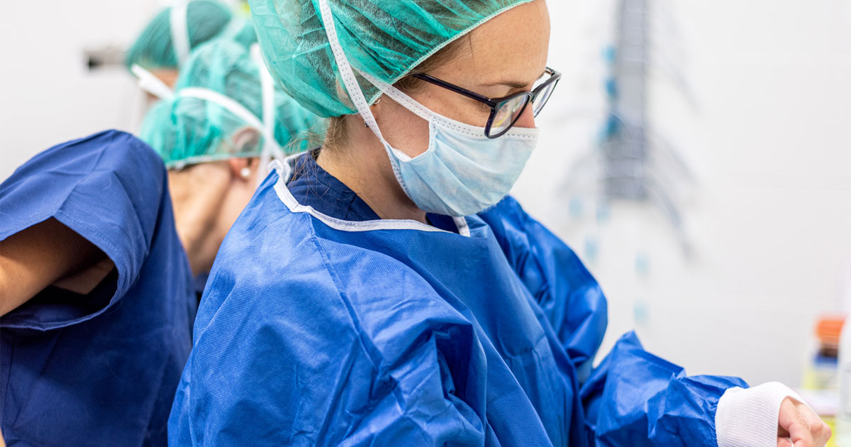 A medical professional wearing protective gear, including mask and gown. 