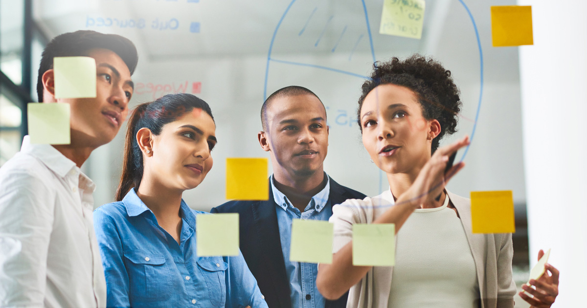 Smiling Multiethnic Business Team With Marker Pen And Stickers Working In Office 