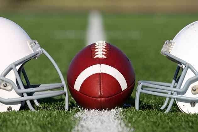 Two football helmets on field