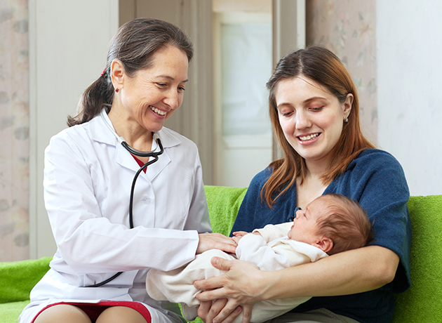 Doctor examining baby that mother is holding Doctor examining baby that mother is holding