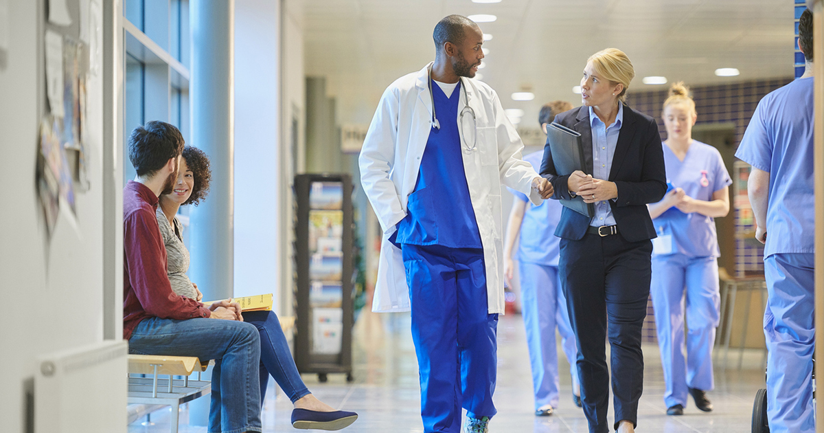 male doctor speaks with a businesswoman