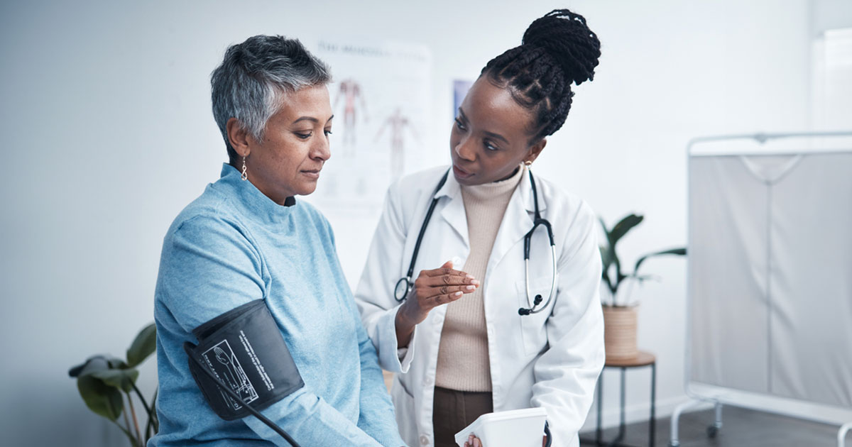 Black female doctor attending an older adult female patient