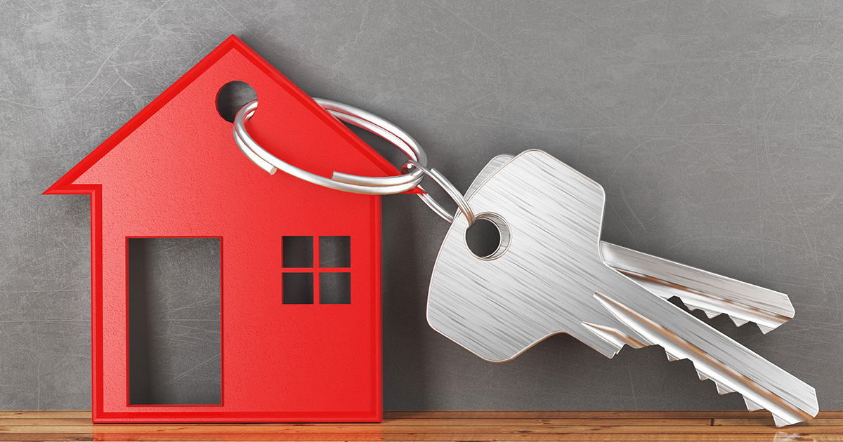 A red house key chain with two keys 