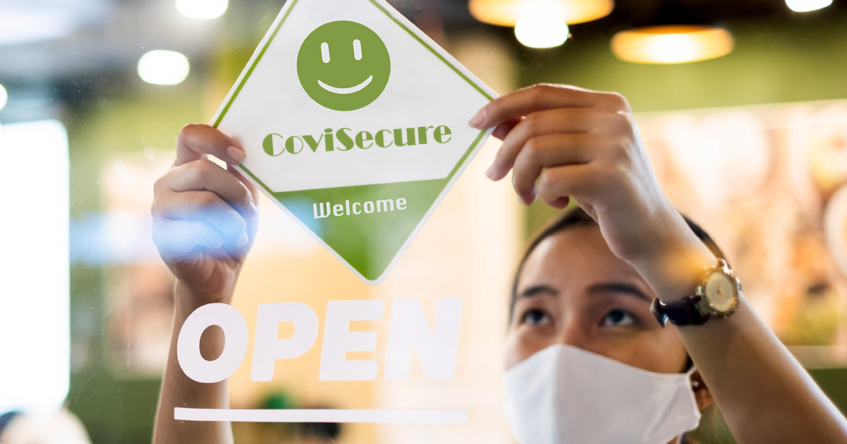 A woman putting a CoviSecure sign on a business window