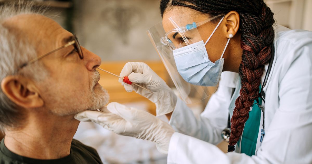 a medical personnel taking a sample for corona virus testing on a patient