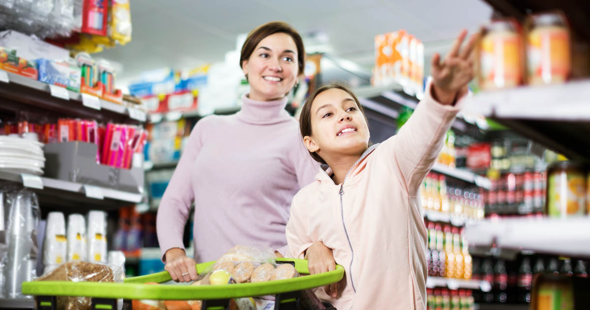 A mother and a daughter shopping in a grocery store.