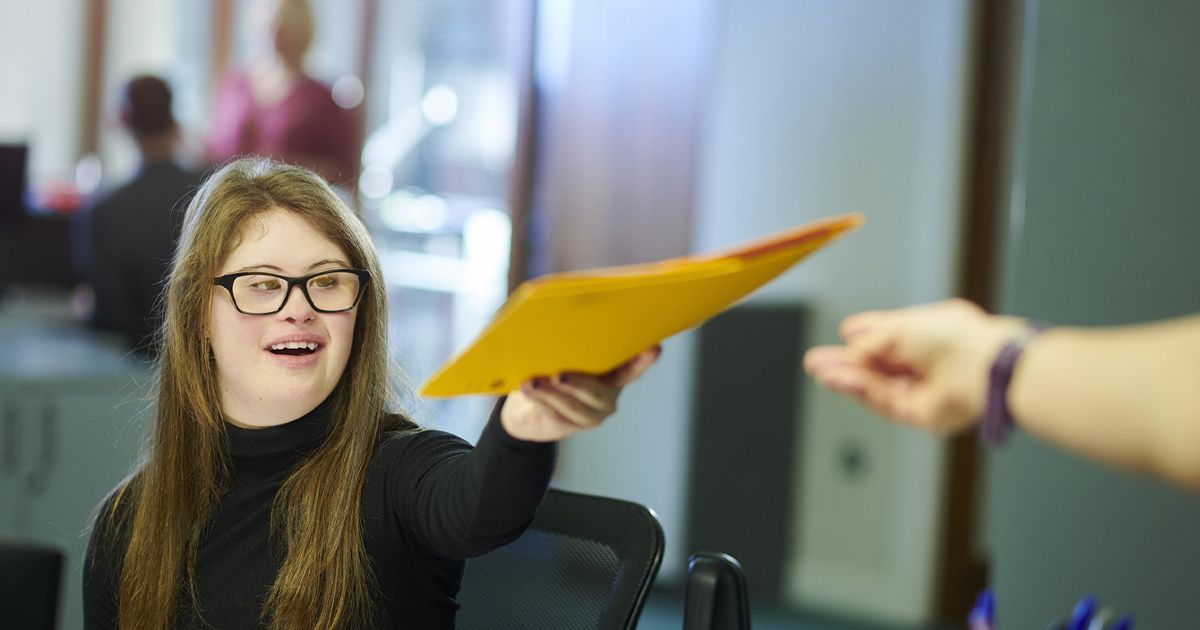 a woman holding a yellow folder