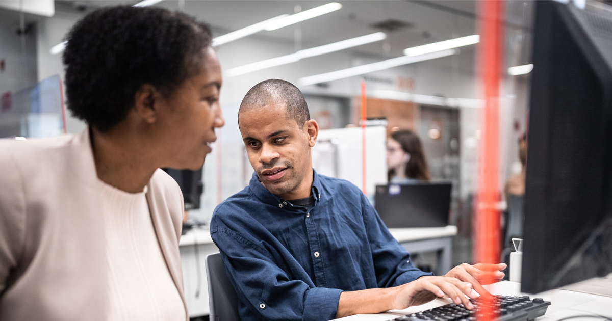 a man and woman looking at a laptop
