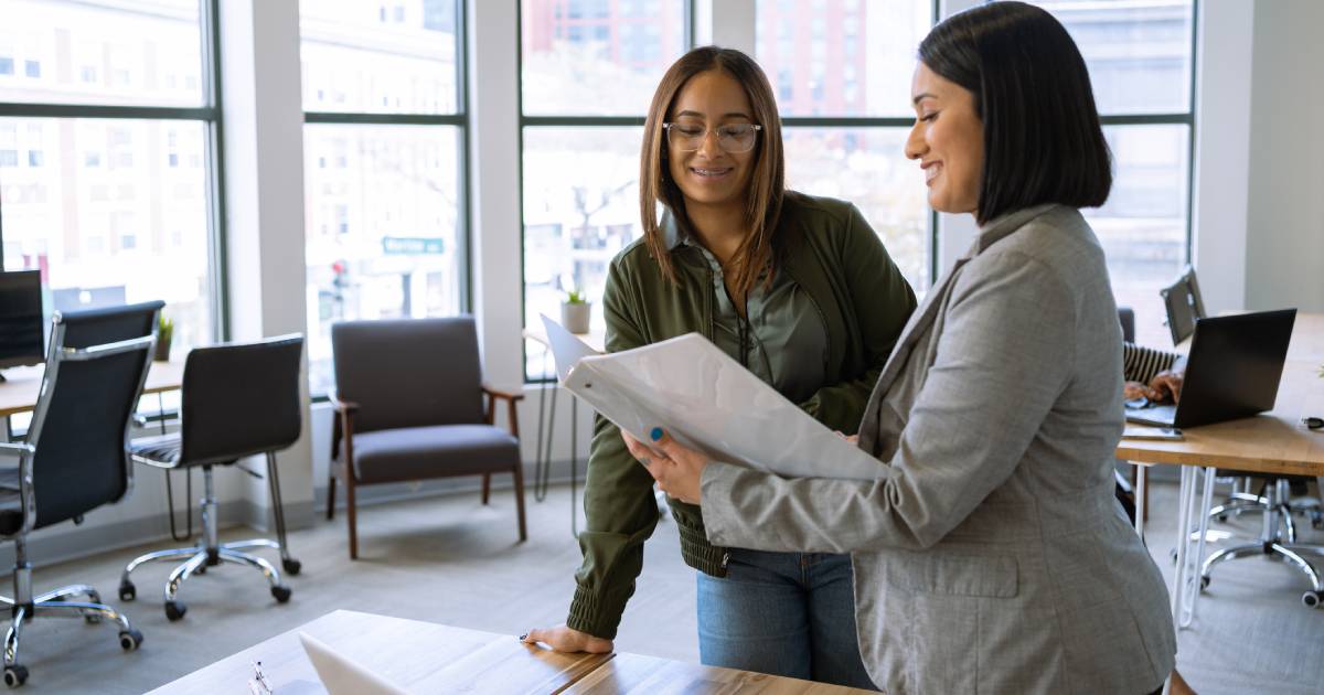 Two women confer in a classroom.