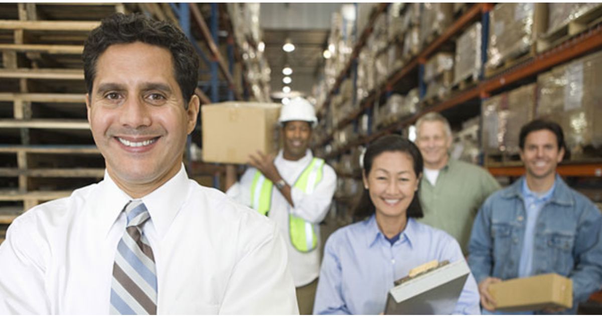 4 warehouse employees and a manager working in a warehouse