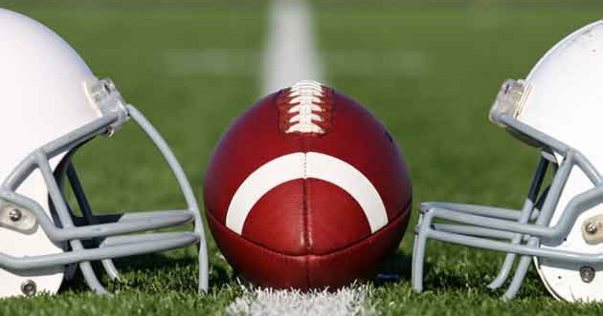 two helmets and a football on a football field