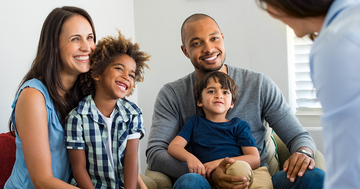 A couple with young children talk with a medical professional. 
