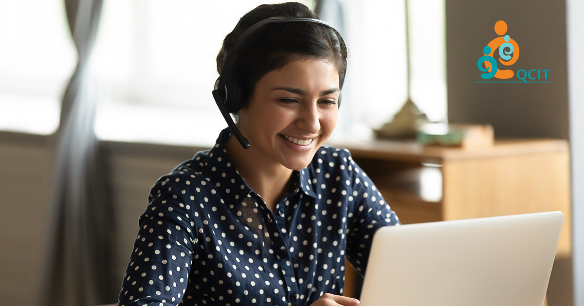 Woman wearing a headset and smiling while attending a webinar